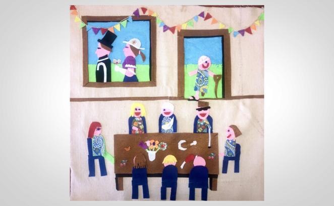 felt artwork showing people around a table
