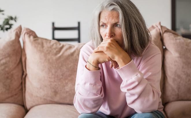 sad and worried woman on couch