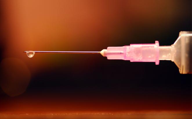 drop of medicine at the tip of a syringe